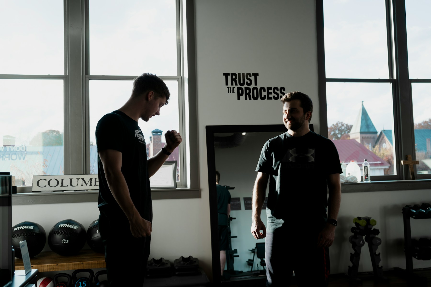 a couple of men standing in front of a window